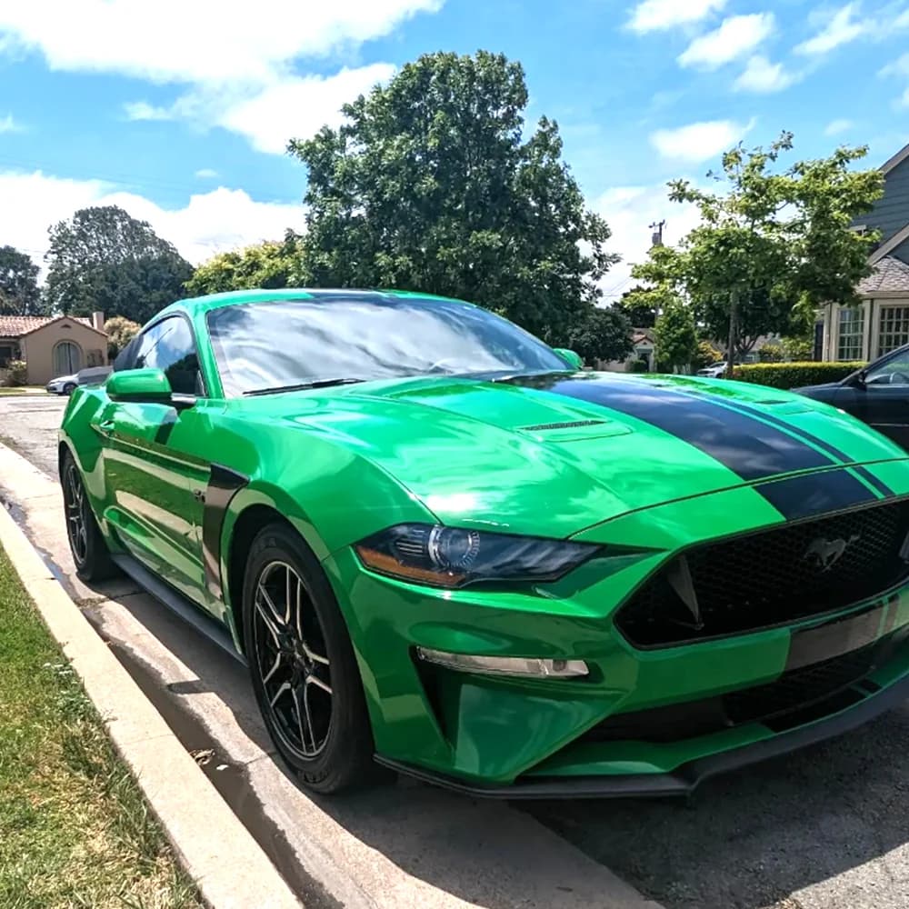 Green Ford Mustang with black racing stripes after a full detail