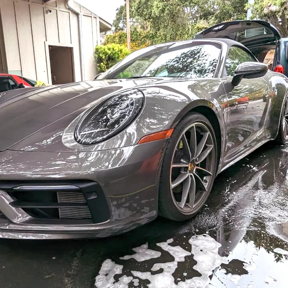 Gray Porsche 911 during a foam wash